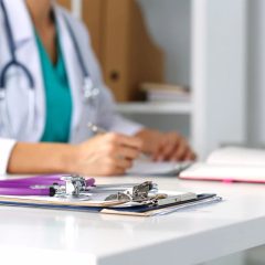 Medical biller reviewing a claim form and an insurance card side by side to check the POS meaning in medical paperwork